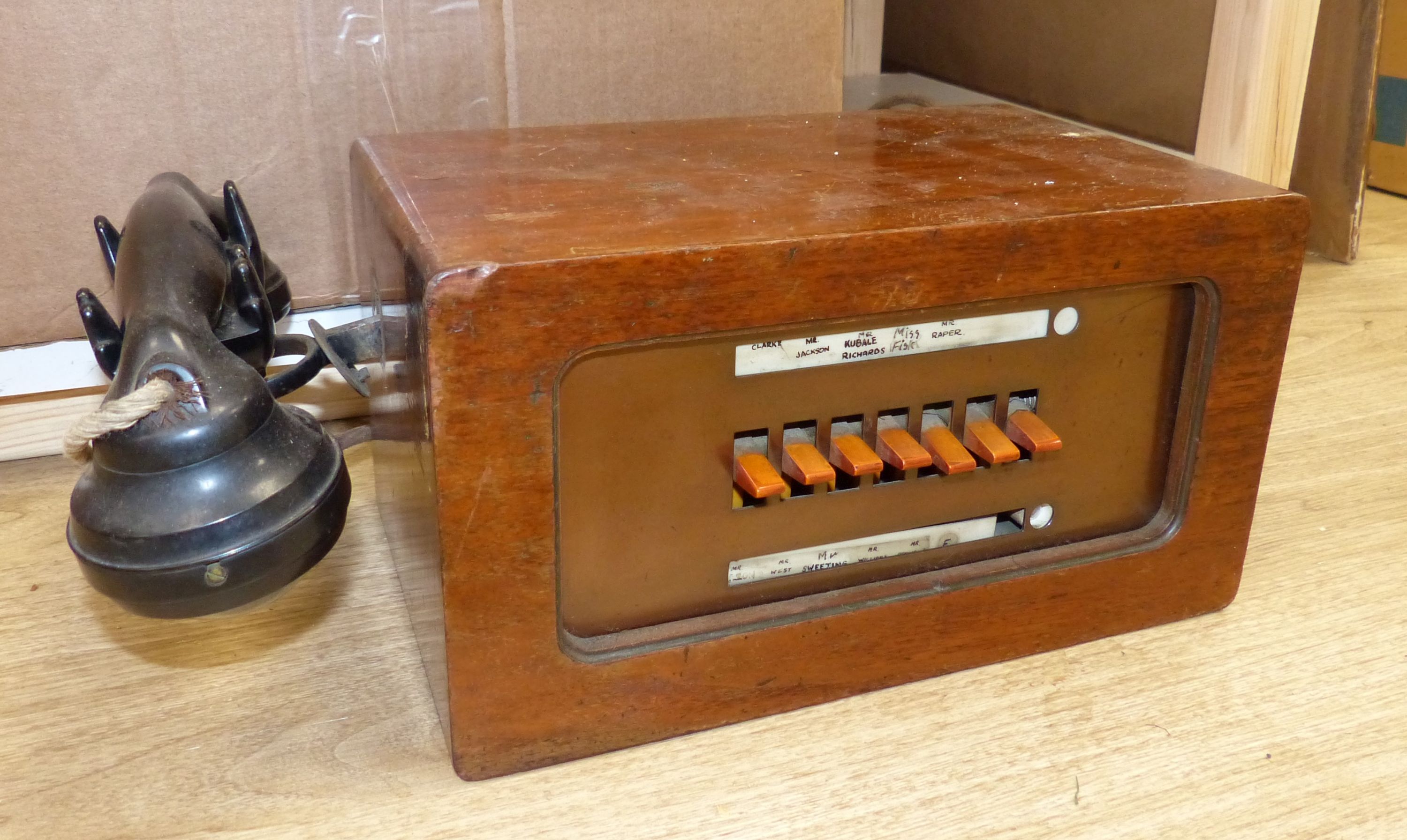 A vintage walnut-cased telephone switchboard with black Bakelite handset